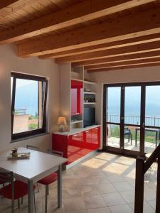 eine Küche mit roten Schränken und Meerblick in der Unterkunft La Quiete 56 Lake view Apartment by Gardadomusmea in Tremosine sul Garda