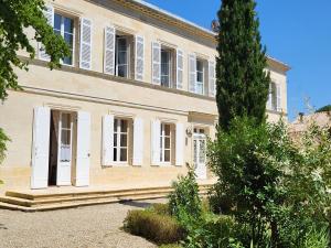 una casa grande con un árbol delante en Domaine de Plisseau, en Le Rigalet