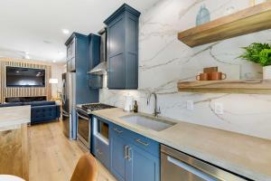 a kitchen with blue cabinets and a sink at The Lofts on 89 Condo Near Bridger Natl Forest! in Afton
