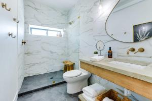 a bathroom with a toilet and a sink and a mirror at The Lofts on 89 Condo Near Bridger Natl Forest! in Afton +22 photos