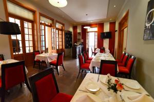 een eetkamer met tafels en rode stoelen in een restaurant bij Camino Plaza in Cochabamba