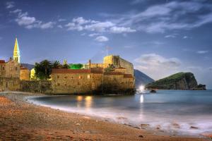 un castello sulla riva di un corpo d'acqua di Solimar a Budua