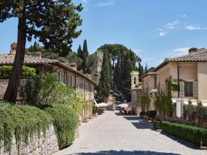eine Straße in einem Dorf mit Häusern und Bäumen in der Unterkunft Rosewood Castiglion del Bosco in Castiglione del Bosco