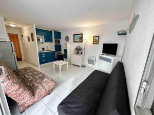 a living room with a couch and a television at Studio - résidence avec piscine in Cap d'Agde