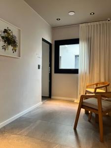 a room with a wooden chair and a window at Casa Papagayo in Córdoba