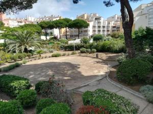 a garden in front of a building with trees and bushes at Studio - résidence avec piscine in Cap d'Agde