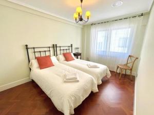 1 dormitorio con 2 camas con almohadas rojas. en housingcoruña SANTA MARGARITA en A Coruña