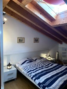 ein Schlafzimmer mit einem großen Bett und einer Holzdecke in der Unterkunft La Quiete 56 Lake view Apartment by Gardadomusmea in Tremosine sul Garda