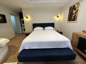 een slaapkamer met een groot bed met een blauwe poef bij Deluxe Apartment In City Center in Tirana