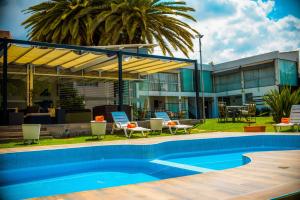 a swimming pool in front of a building with a house at Camino Plaza in Cochabamba