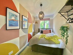 a bedroom with a bed and a colorful wall at Coventry Huge 4bed 2bath Private Parking NEC by Empower Homes in Coventry