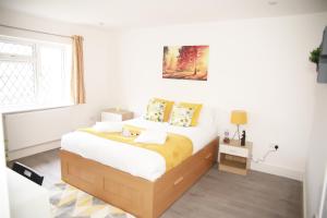 a white bedroom with a bed and a window at Deluxe 4 bedroom House in The Hyde