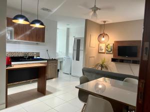 eine Küche und ein Wohnzimmer mit einem Sofa und einem Tisch in der Unterkunft Hotel APART Zuccolotto 202 in Aracruz