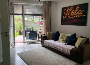 uma sala de estar com um sofá em frente a uma porta em Jezerní apartmán s terasou a saunou v Lakepark Residence em Doksy