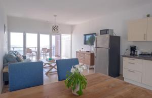 eine Küche und ein Wohnzimmer mit einem Tisch und einem Kühlschrank in der Unterkunft Whitehouse Lagun Apartments in Lagun