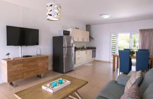 eine Küche und ein Wohnzimmer mit einem Sofa und einem Kühlschrank in der Unterkunft Whitehouse Lagun Apartments in Lagun