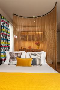 a bedroom with a large bed with yellow pillows at Upon Angels - Adults Only in Lisbon