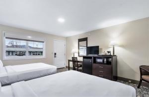 a hotel room with two beds and a television at Top Notch Inn in Gorham