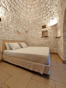 a bedroom with a bed in a stone wall at Il Giardino degli Ulivi in Castellana Grotte