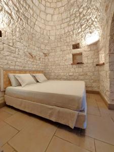 una camera con un letto in una parete in pietra di Il Giardino degli Ulivi a Castellana Grotte