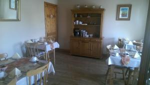 a dining room with tables and chairs and a book shelf at Suantrai Accommodation in Doolin