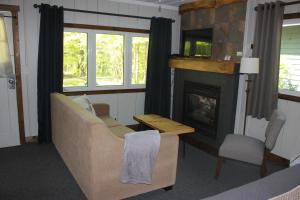 uma sala de estar com um sofá e uma lareira em Trillium Resort & Spa em Port Sydney