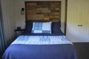 a bedroom with a blue bed with a wooden headboard at Trillium Resort & Spa in Port Sydney