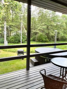 un porche cubierto con mesa, sillas, mesa y mesa en Farm hostel - The hause 1, en Elektrėnai