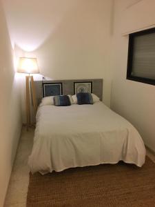 a bedroom with a large white bed with blue pillows at Sweet Home in Durazno