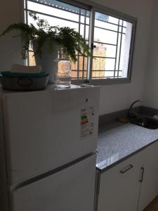 a kitchen with a white refrigerator and a window at Sweet Home in Durazno