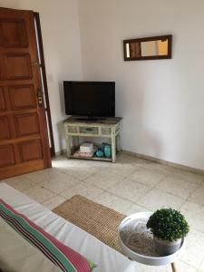 a living room with a flat screen tv and a table at Sweet Home in Durazno