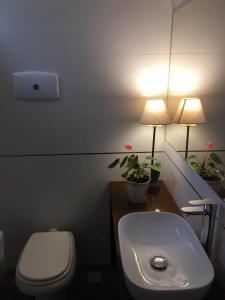 a bathroom with a toilet and a sink and a lamp at Sweet Home in Durazno