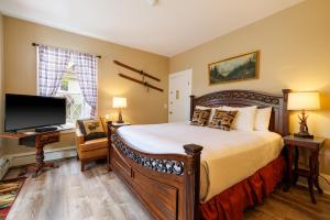 Mira Monte Inn & Suites في بار هاربور: غرفة نوم بسرير كبير وتلفزيون بشاشة مسطحة