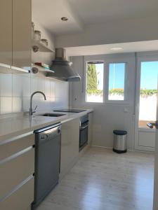 eine weiße Küche mit einer Spüle und einem Herd in der Unterkunft Comfort & Calidad VILLA Senator Los Alcazares-Lomas del Rame in Los Alcázares