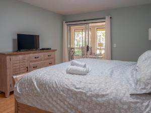 een slaapkamer met een groot bed en handdoeken bij 1159 Summerwind Cottage in Seabrook Island