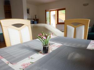 einen Esstisch mit einer Blumenvase darauf in der Unterkunft Apartment Jalps 1 in beautiful Bohinjska Bistrica in Bohinj