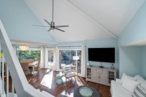 een woonkamer met blauwe muren en een flatscreen-tv bij 774 Spinnaker Beach House in Seabrook Island