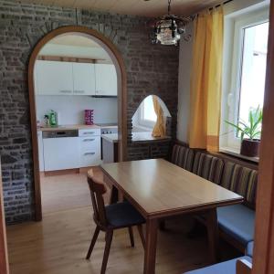 a kitchen with a wooden table and a dining room at Ferienwohnung Patrycja in Weissenbach am Lech
