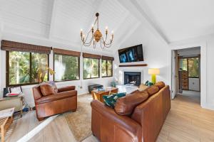 uma sala de estar com mobiliário de couro e um lustre em 804 Treeloft Cottage em Seabrook Island
