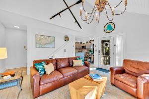 a living room with leather furniture and a chandelier at 804 Treeloft Cottage in Seabrook Island