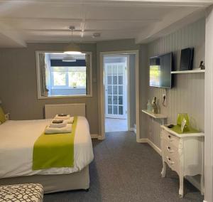 a bedroom with a large bed and a window at Petherton Cottage Studios in Ringwood