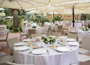 a table set up for a wedding with white tables and chairs at Hotel Della Valle in Agrigento