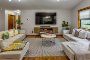 a living room with couches and a flat screen tv at Pet-Friendly Wellington Vacation Rental on Canal! in Wellington