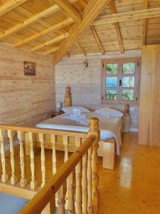 a log cabin bedroom with a bed and a staircase at Nashos Bungalows in (( Spile ))