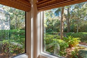 a window in a house looking out at a garden at 1345 Pelican Watch Villa in Seabrook Island