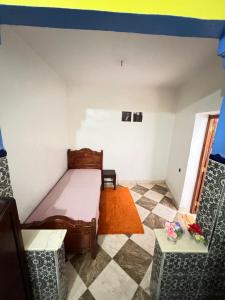 1 dormitorio pequeño con 1 cama y 2 sillas en JadHouse, en Chefchaouen