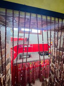 Cama en habitación con cortinas rojas en JadHouse, en Chefchaouen