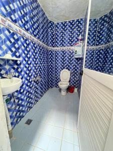 Baño de azulejos azules con aseo y lavamanos en JadHouse, en Chefchaouen