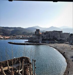 vistas a una playa con un castillo en el fondo en Appartement T6. Emplacement et vue mer d'exception, en Collioure