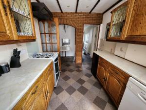 a kitchen with wooden cabinets and a stove top oven at Sheldon Shared House in Birmingham